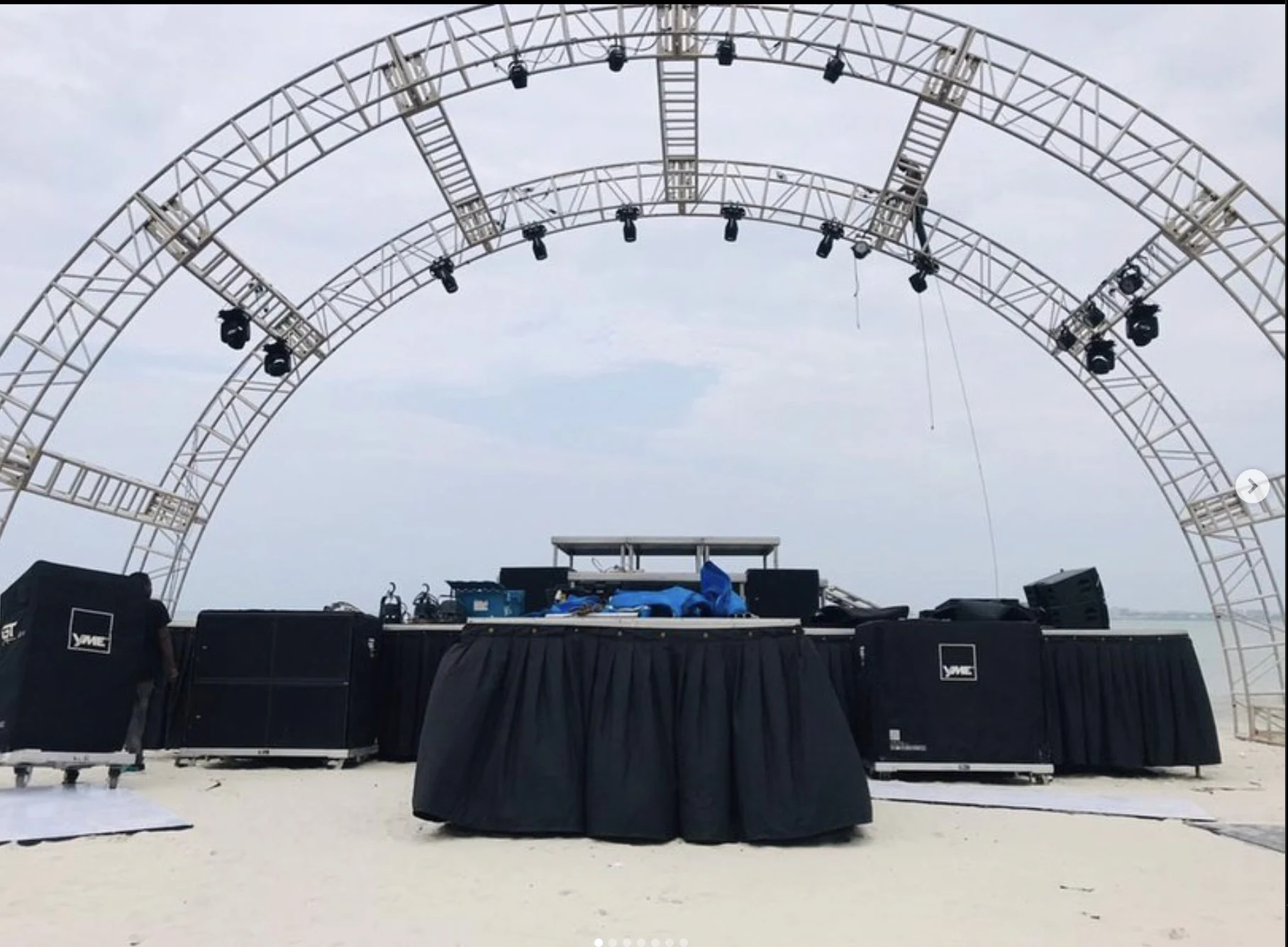 Arched stage structure and lighting rig in an open event venue