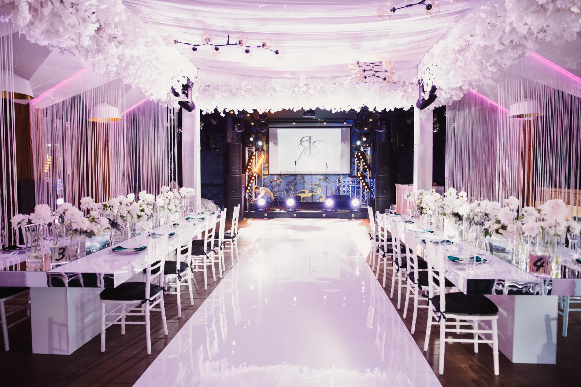 Elegant wedding venue with an aisle, guest seating and a stage